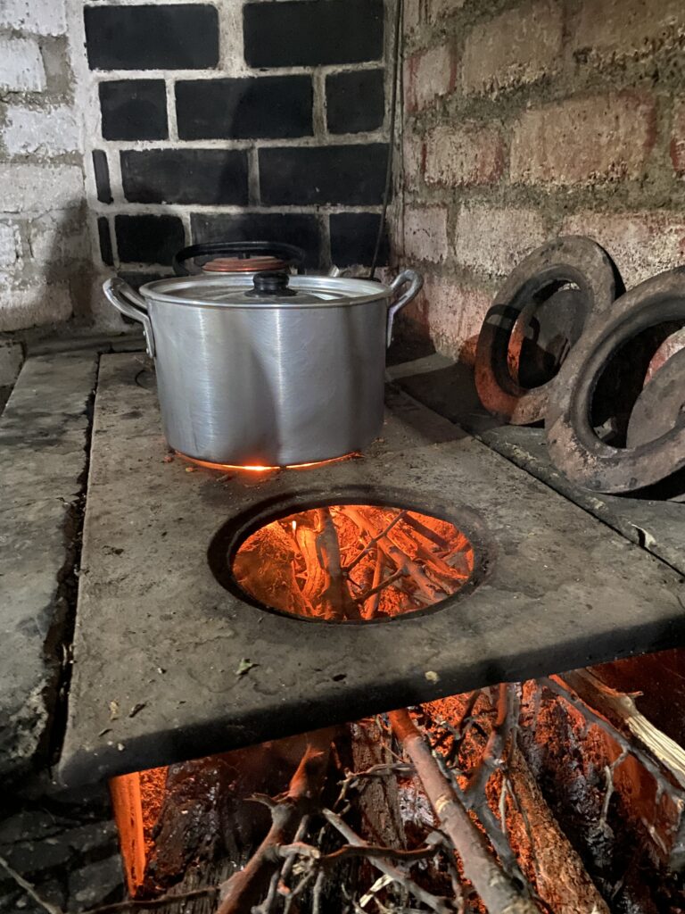 Cocina de leña de ladrillo, equipada con una plancha de metal que incluye tres hornillas de diferentes tamaños para adaptarse a diversas ollas. Cada hornilla cuenta con su tapa ajustable en dos medidas, permitiendo regular la llama y conservar el calor de manera eficiente.